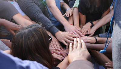 hands reaching in for a huddle