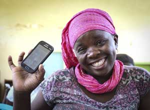 Tala customer holds up smart phone with Tala app on the screen